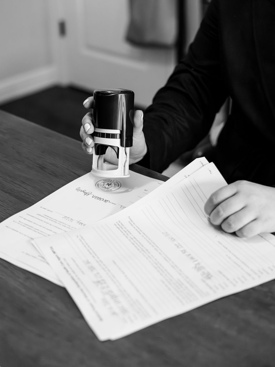A Texas notary applying an official embossed seal stamp to a signed document